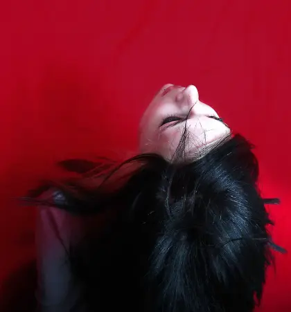 artsy pose of a woman on a red background