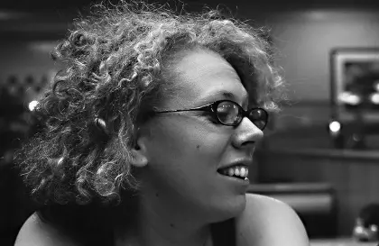 woman with curly hair looking off while smiling